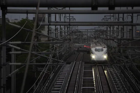 雨の線路を駆ける白い影