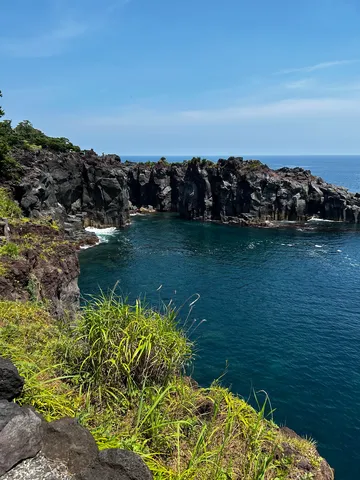黒い岩と紺の海の刻