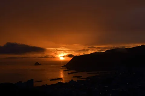 黄金の夕陽と港町のシルエット