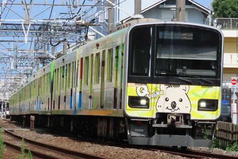 個性的なデザインの電車、走行シーン