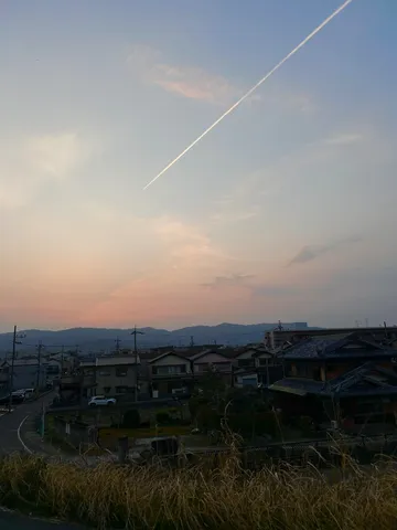 空を彩る飛行機雲と静かな町並み