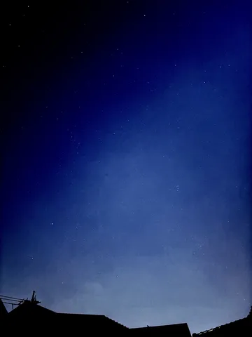 青く輝く夜空と屋根のシルエット