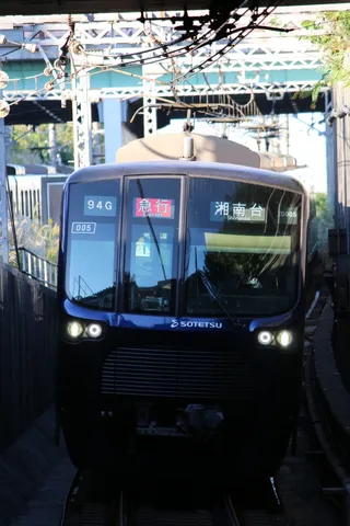 架線と青い列車の一瞬