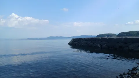 静寂の波打ち際、石積みの防波堤