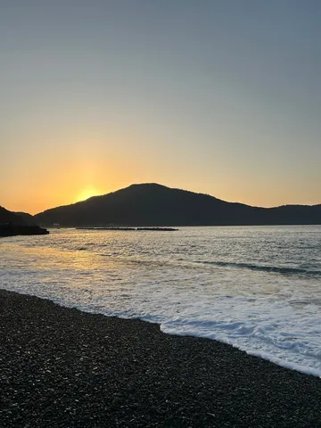 山影に寄り添う夕焼けの波