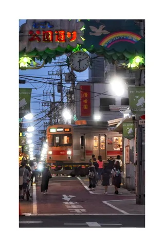 夕暮れの街角を駆ける電車