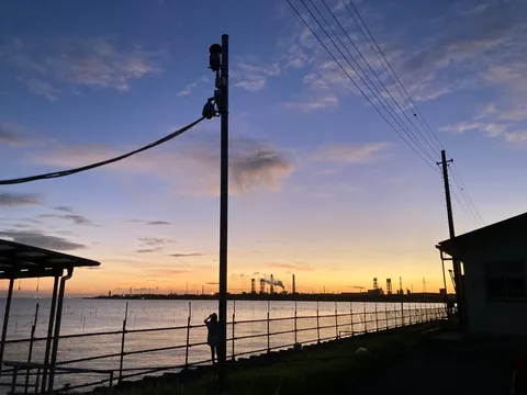 工場地帯の夕暮れ、一人佇むシルエット