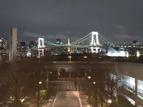 都会の夜景に架かる虹色の橋