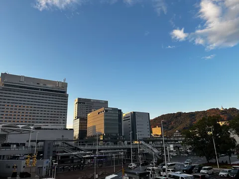 夕暮れのビル街と山並み