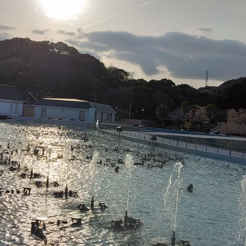 夕暮れの水辺に光る噴水