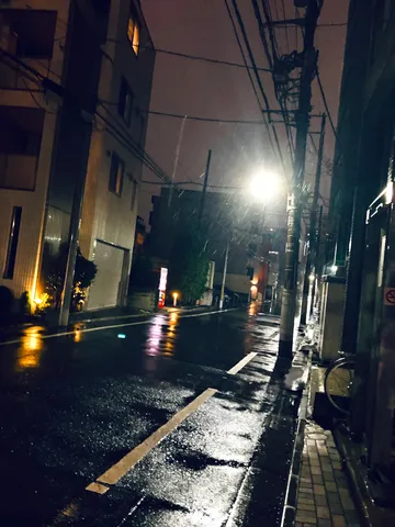 雨夜の街角に光の跳ね