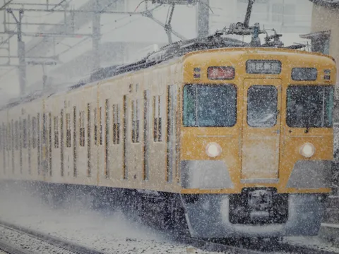 吹雪の中を走る黄色い列車