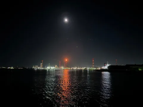 月夜の港、灯る工場のシルエット