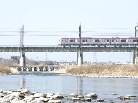 川を渡る電車と鉄塔