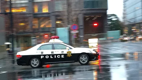 雨の夜を走る警察車両