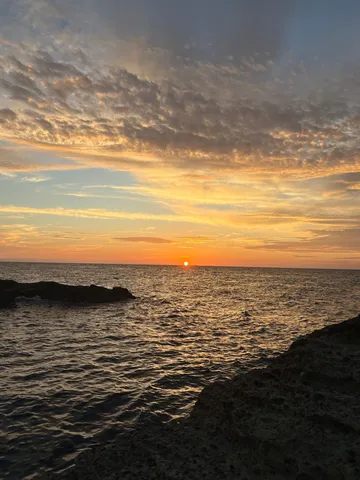 海に沈む夕日、岩場のシルエット