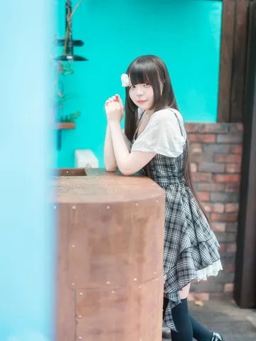 水色の壁とチェックのワンピース
