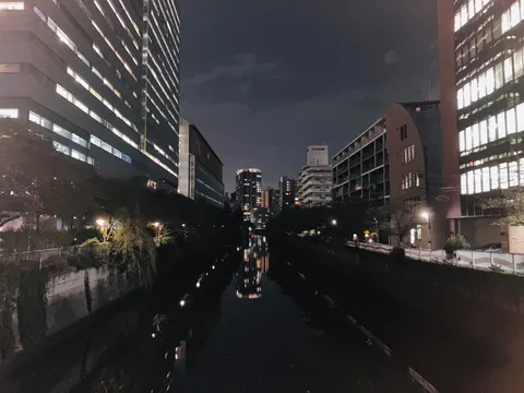 都会の夜、水面の映し出す灯り