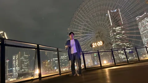 観覧車と街の夜景、そして佇む人
