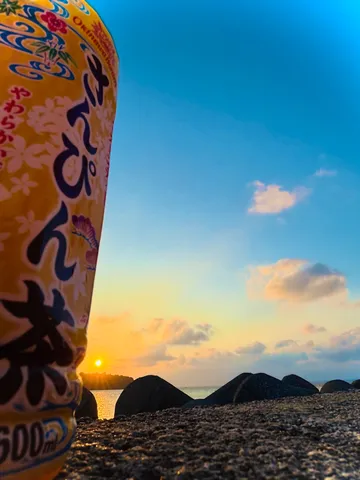 夕暮れの海と風の布が映える