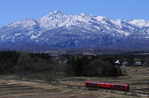 雪山と赤い列車、春の風景