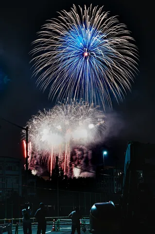 夜空に咲く青い花火と人影