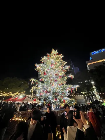 キラキラ輝くクリスマスツリーと人々