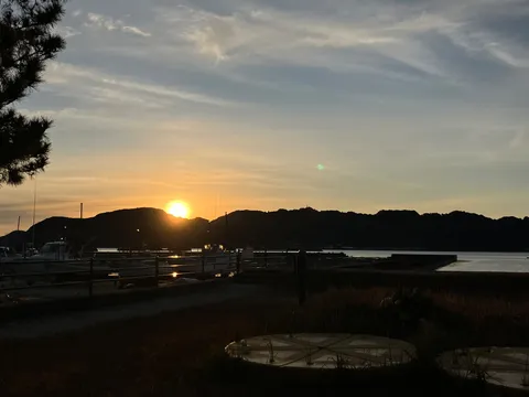 山並みに沈む太陽と港の静けさ