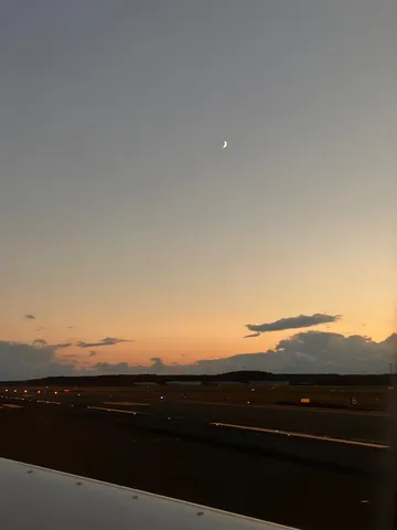 夕暮れ滑走路に灯る光と三日月