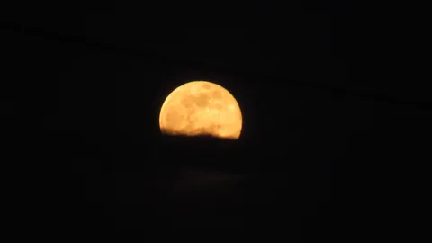 夜空に浮かぶ、オレンジ色の月