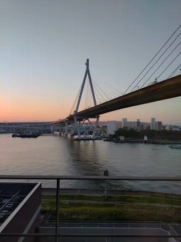 夕暮れ時の吊り橋と都会の対比