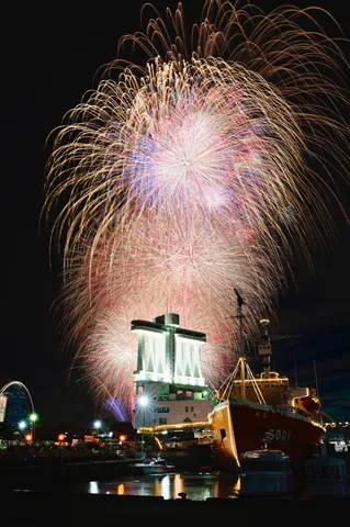 夜空に咲く花火と港の輝き