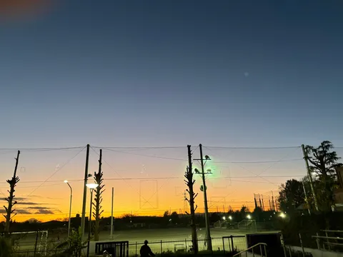 夕暮れのグラウンド、灯る光