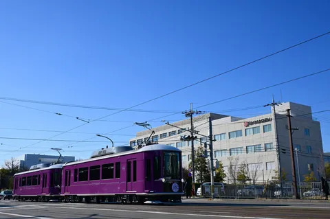 青空と鮮やかな紫色の京電車