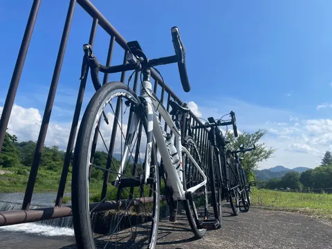 青空と河原のロードバイク