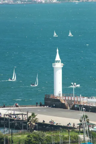 灯台とヨット、夏の海辺の風景