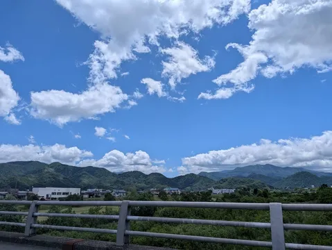 雨上がり、新緑の山並みと広がる青空