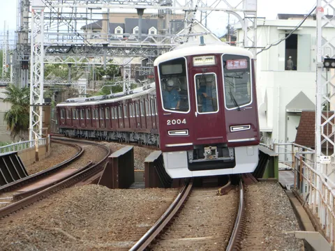 カーブを曲がるワインレッドの電車