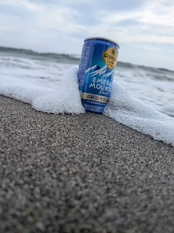 波が包むコーヒー缶