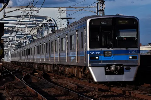 夕暮れ時の都会を駆ける銀色列車