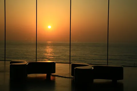 水平線に溶ける夕陽とモダンな椅子