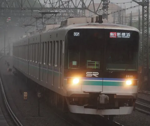 雨の日の駅、電車が発車