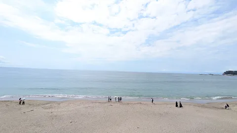 夏の海辺、遠い空と砂浜