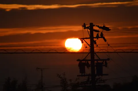 電線と夕陽のシルエット