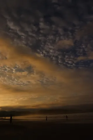 夜の海辺に染まる光雲