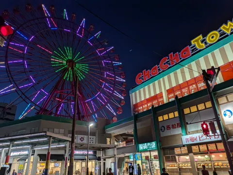 夜空に咲く光の観覧車と街