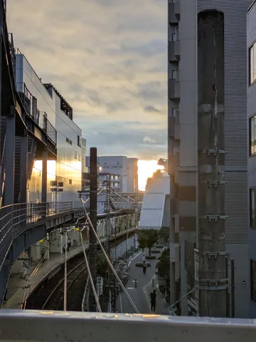 夕暮れの都会、旅立ちの線路