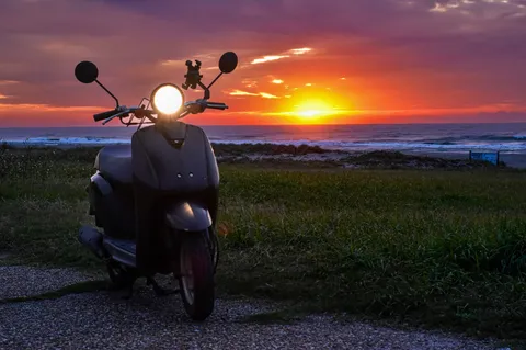 海辺の夕日、スクーターの灯り