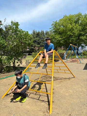 公園の黄色い遊具と少年たち