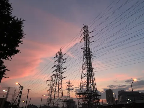 夕焼けに染まる鉄塔と街の灯